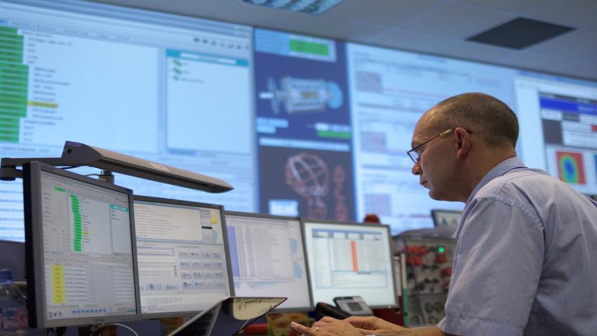 Man looking at multiple monitors.