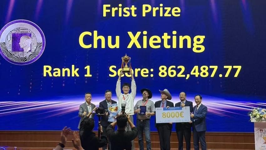man on stage holding trophy
