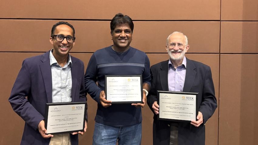 Three men holding awards